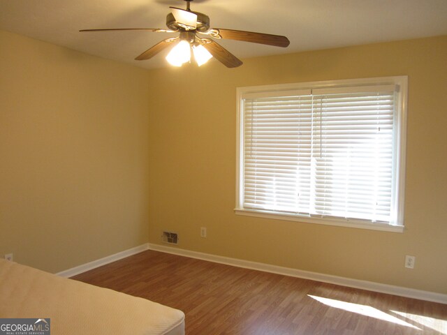 empty room with ceiling fan and wood-type flooring