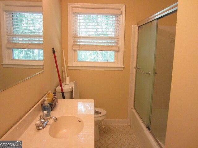 full bathroom with vanity, combined bath / shower with glass door, and toilet