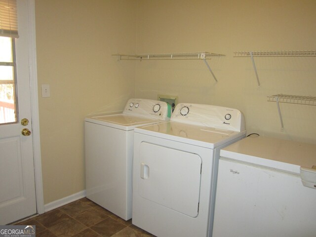 washroom with washer and clothes dryer and dark tile patterned flooring