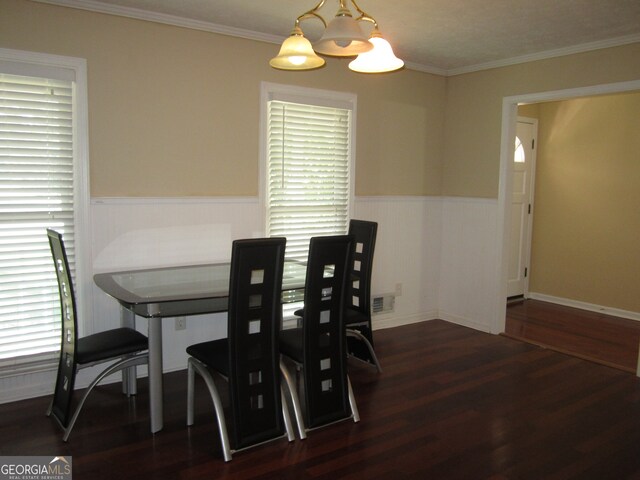 dining area with crown molding, dark hardwood / wood-style floors, and a chandelier