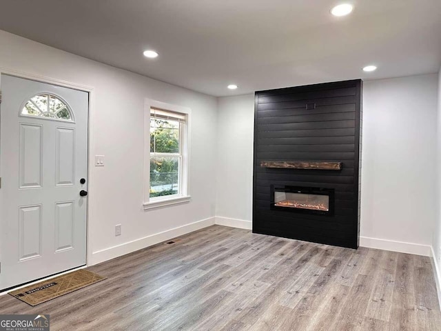 foyer with light hardwood / wood-style flooring and a fireplace