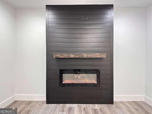 interior details with a large fireplace and wood-type flooring