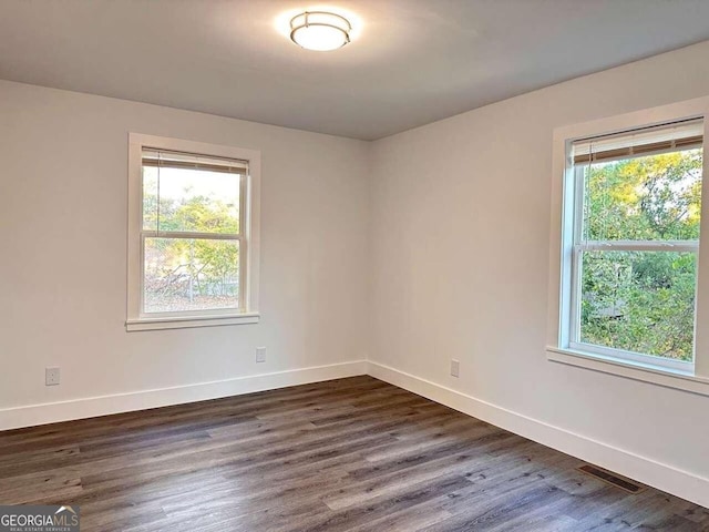 unfurnished room featuring dark wood-type flooring