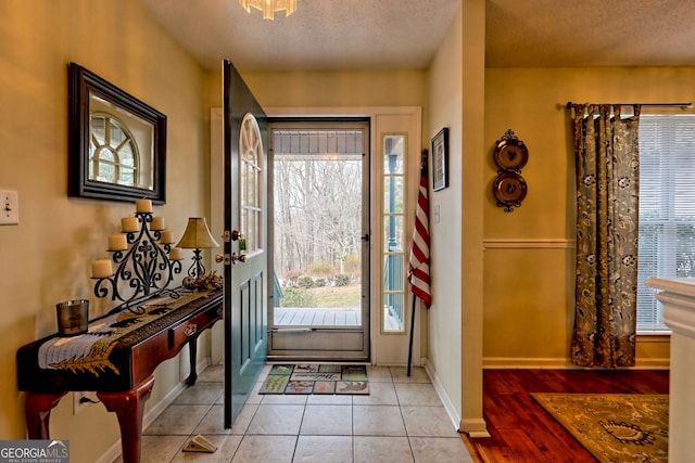 tiled entryway featuring a wealth of natural light and a textured ceiling