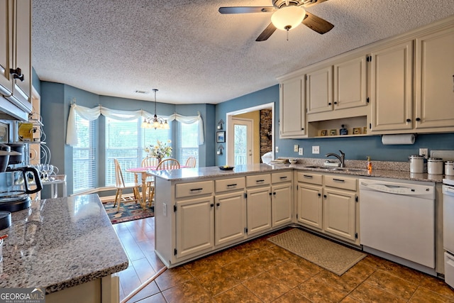 kitchen featuring sink, white dishwasher, kitchen peninsula, pendant lighting, and light stone countertops