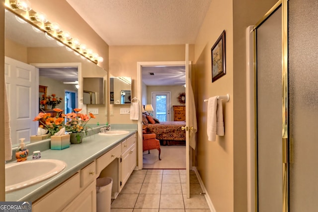 bathroom with walk in shower, tile patterned floors, a textured ceiling, and vanity