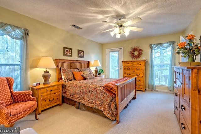 bedroom with access to exterior, light colored carpet, a textured ceiling, and ceiling fan