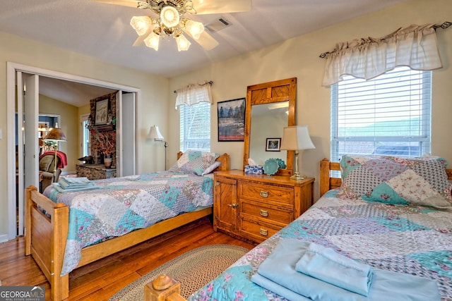 bedroom featuring lofted ceiling, hardwood / wood-style floors, a closet, and ceiling fan