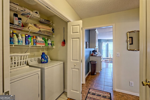 clothes washing area featuring washer and clothes dryer, tile patterned flooring, and a textured ceiling