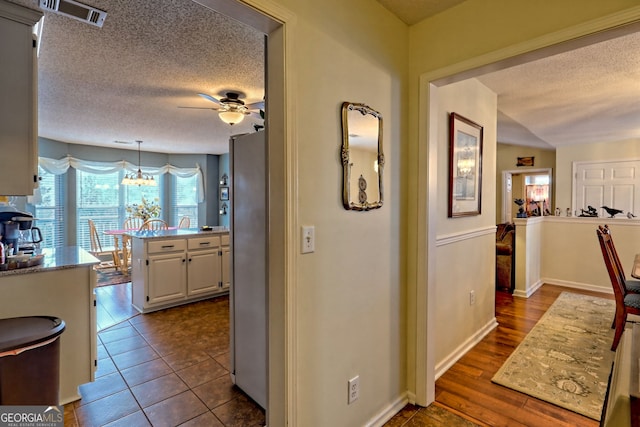 corridor with dark hardwood / wood-style flooring and a textured ceiling