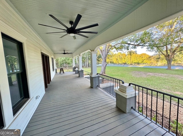 deck with a yard and ceiling fan