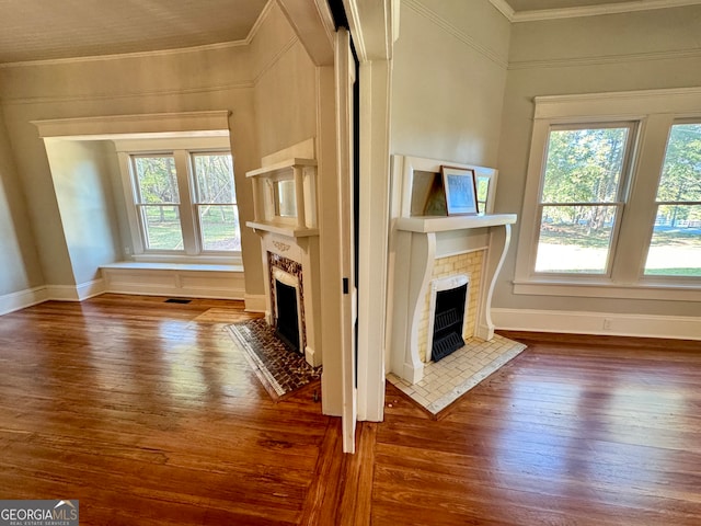 unfurnished living room featuring wood-type flooring, a wealth of natural light, and a fireplace