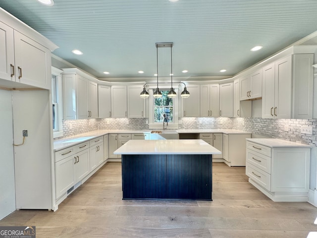 kitchen featuring a center island, white cabinets, pendant lighting, and light hardwood / wood-style floors