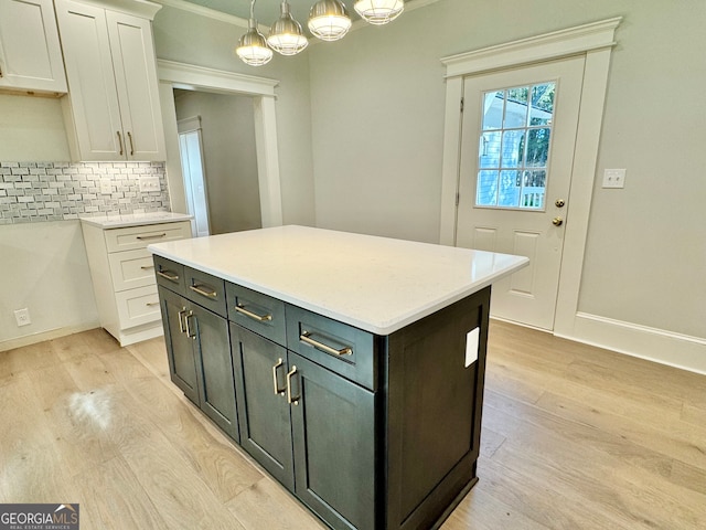 kitchen with decorative backsplash, light hardwood / wood-style flooring, a center island, pendant lighting, and white cabinetry