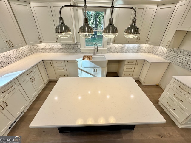 kitchen featuring light stone countertops, sink, dark wood-type flooring, and backsplash