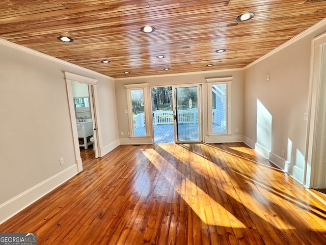 empty room featuring crown molding, wood-type flooring, and wooden ceiling