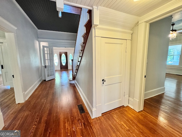 hall with french doors, a healthy amount of sunlight, and wood-type flooring