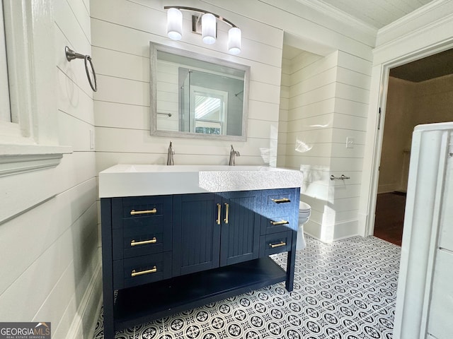 bathroom with toilet, ornamental molding, and vanity