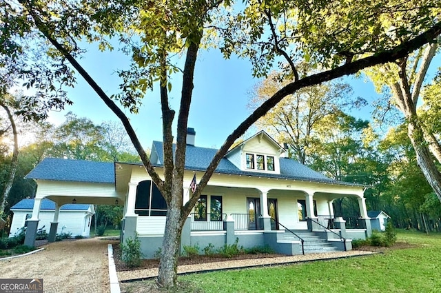 view of front of home with a front yard, a carport, and a porch