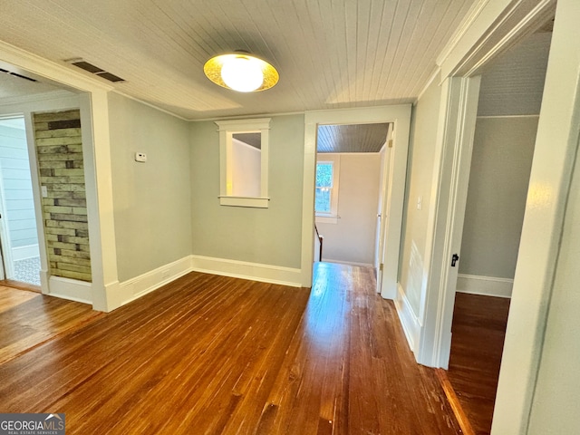 hallway with hardwood / wood-style flooring, ornamental molding, and wooden ceiling