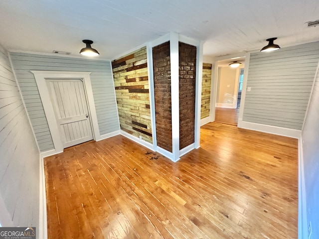 empty room featuring hardwood / wood-style flooring and wood walls