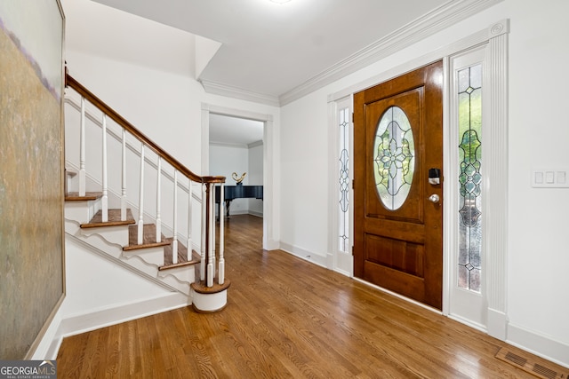 entrance foyer featuring crown molding, hardwood / wood-style flooring, and plenty of natural light