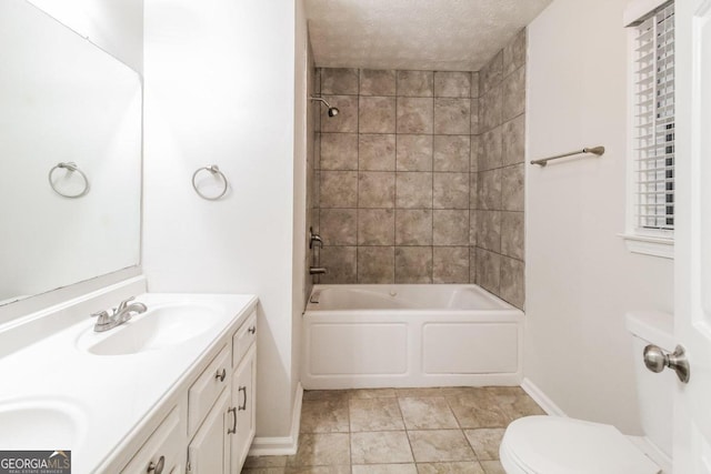 full bathroom featuring tiled shower / bath, vanity, a textured ceiling, and toilet