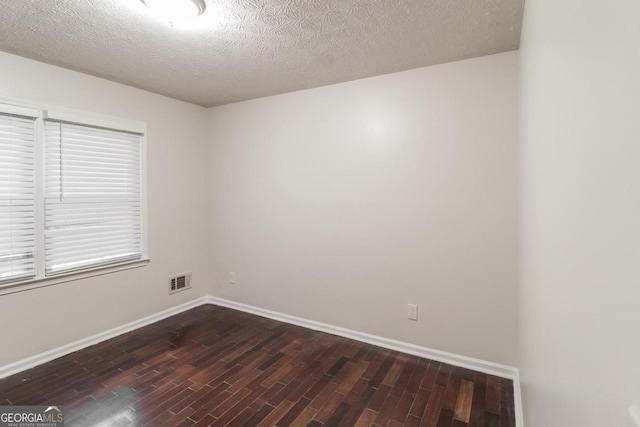 unfurnished room featuring dark hardwood / wood-style floors and a textured ceiling