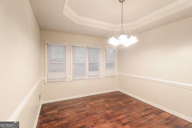 empty room featuring crown molding, a textured ceiling, a notable chandelier, and a raised ceiling