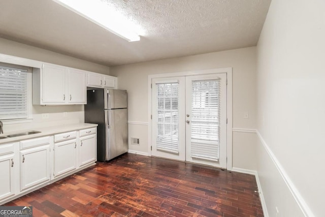 kitchen featuring french doors, dark hardwood / wood-style floors, sink, white cabinetry, and stainless steel refrigerator