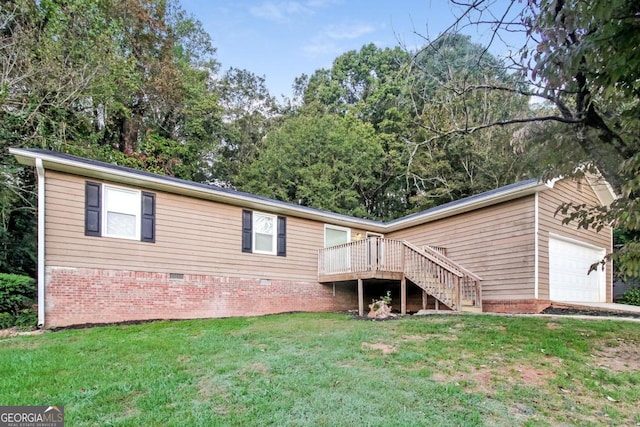 back of property with a deck, a yard, and a garage