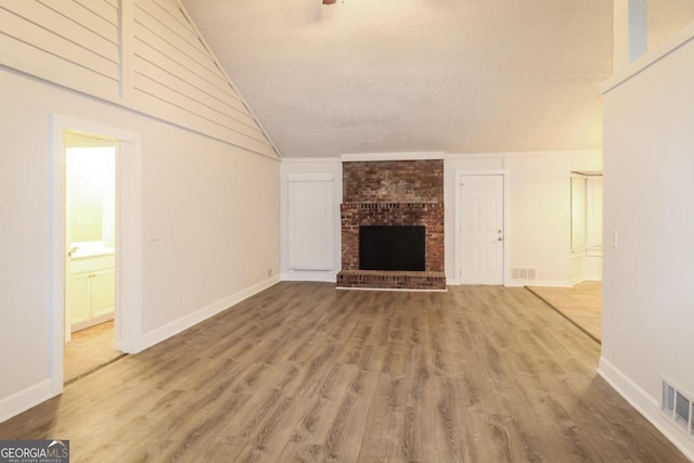 unfurnished living room with lofted ceiling, hardwood / wood-style floors, and a fireplace