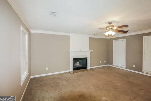 unfurnished living room featuring ornamental molding, carpet, a fireplace, and ceiling fan