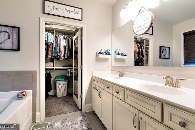 bathroom with tile patterned floors, a tub, and vanity