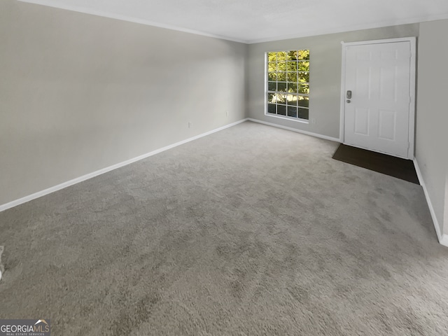 carpeted spare room featuring crown molding