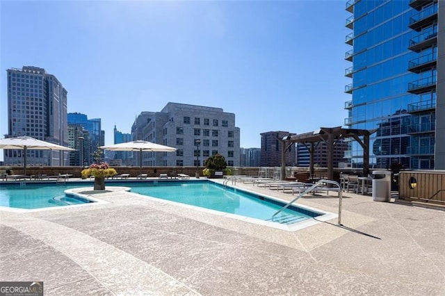 view of swimming pool with a patio and a pergola