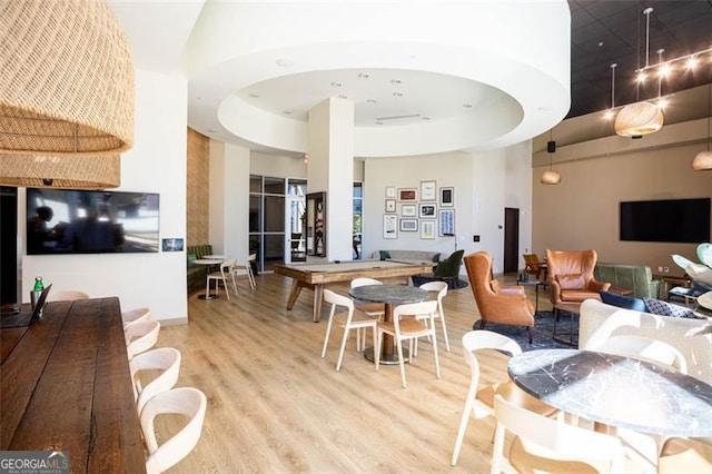 interior space with a high ceiling, hardwood / wood-style floors, and a raised ceiling