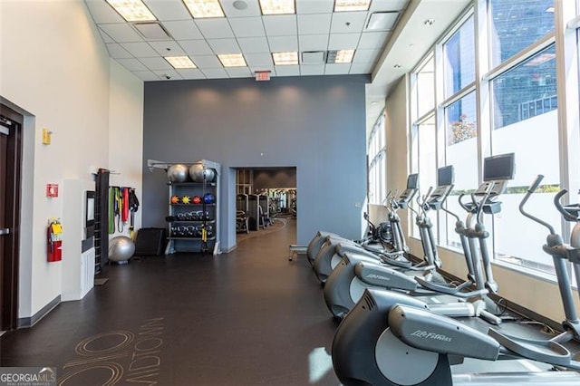 gym featuring a paneled ceiling and a towering ceiling