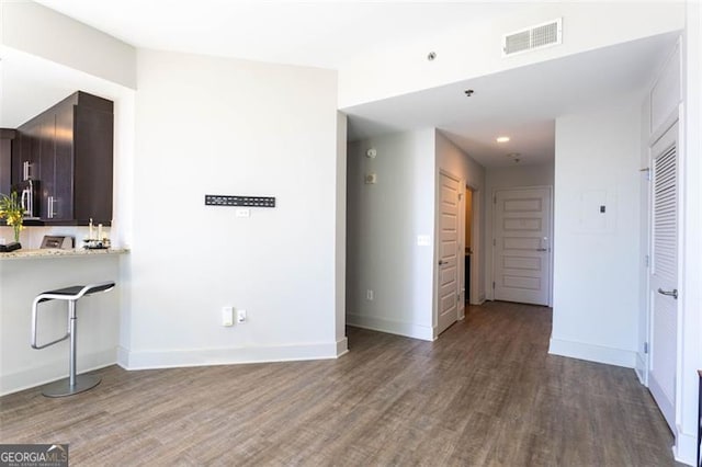 interior space with dark brown cabinets and dark hardwood / wood-style flooring