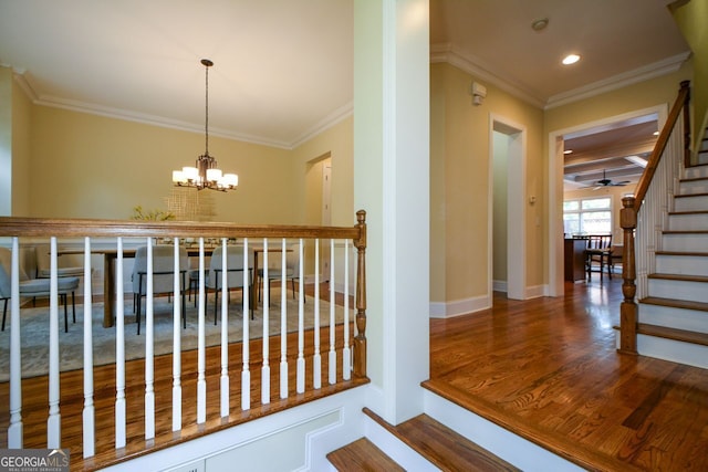 corridor featuring crown molding, an inviting chandelier, and hardwood / wood-style floors