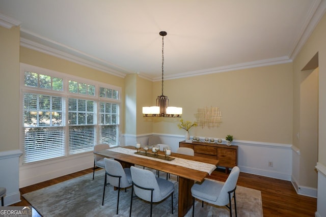 dining space with ornamental molding, a chandelier, and dark hardwood / wood-style floors