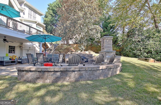 exterior space with an outdoor stone fireplace, a balcony, and ceiling fan