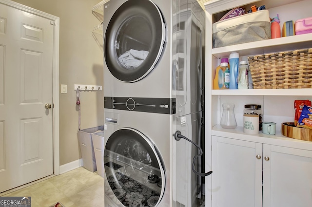 laundry area featuring cabinets and stacked washing maching and dryer