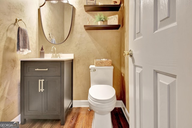 bathroom with vanity, toilet, and wood-type flooring