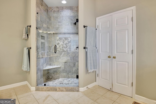 bathroom with tile patterned floors and a shower with door