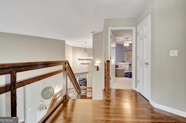 corridor featuring hardwood / wood-style flooring and a notable chandelier