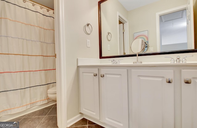 bathroom featuring curtained shower, tile patterned flooring, vanity, and toilet