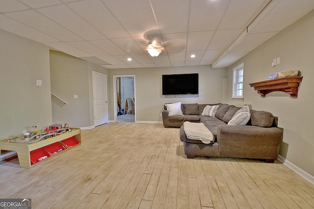 living room featuring light hardwood / wood-style floors and a drop ceiling