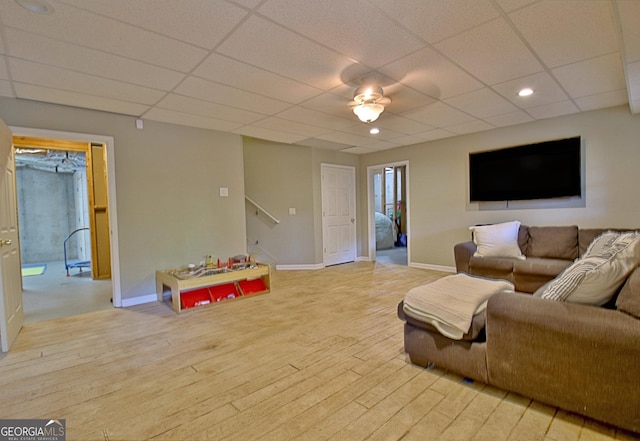 living room with a paneled ceiling and light hardwood / wood-style flooring