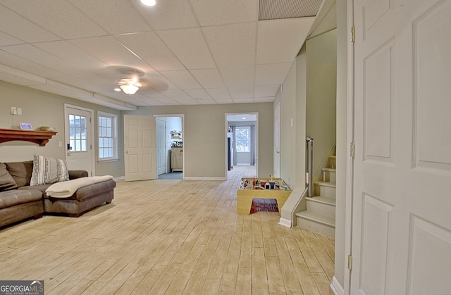 living room with a paneled ceiling and light hardwood / wood-style flooring